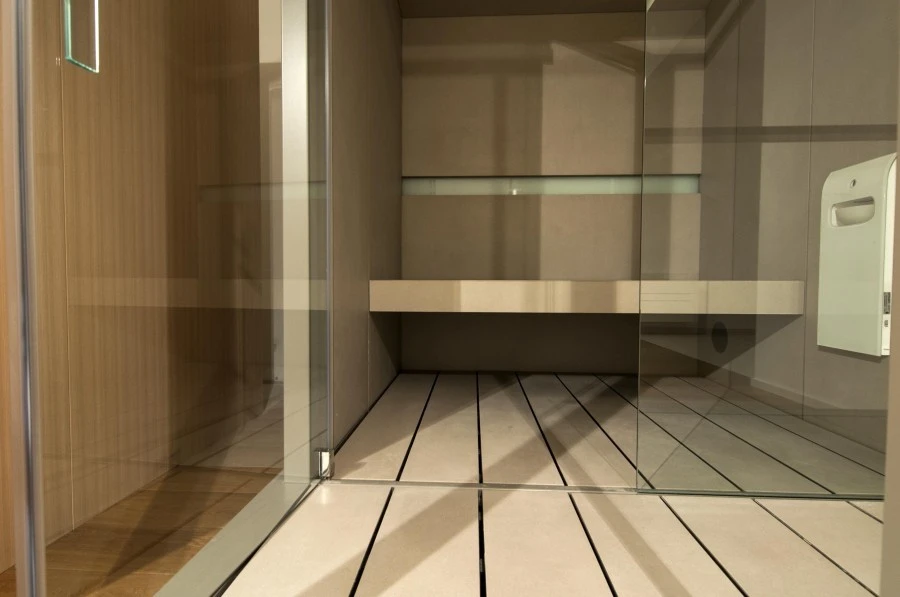 Dettaglio porta in vetro temperato e panca in Gres laminato